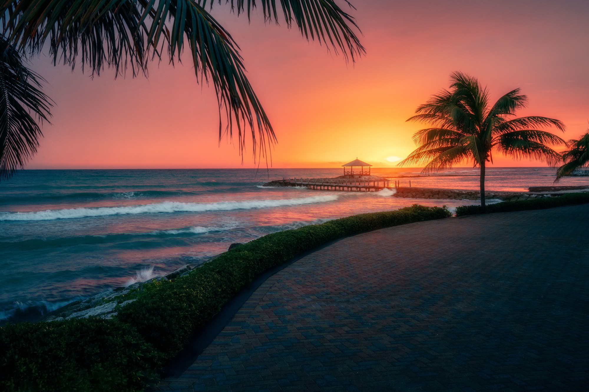 Stunning Montego Bay, Jamaica, Caribbean Sea at sunset with palm trees and a pier