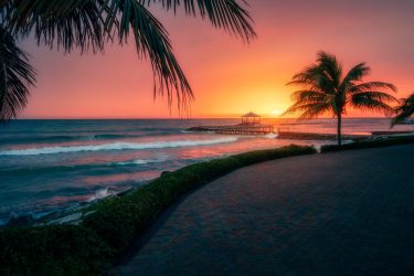 Stunning Montego Bay, Jamaica, Caribbean Sea at sunset with palm trees and a pier